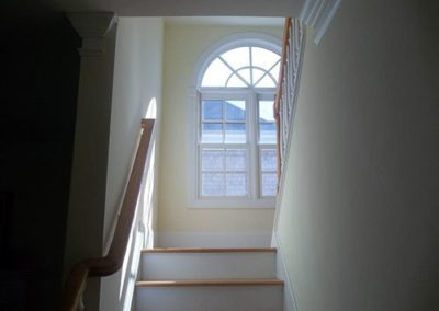 a stairway with a yellow painted wall