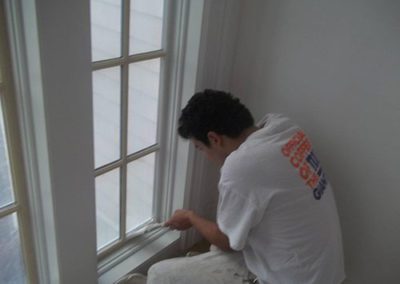 a man painting a window
