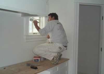 a man painting a window